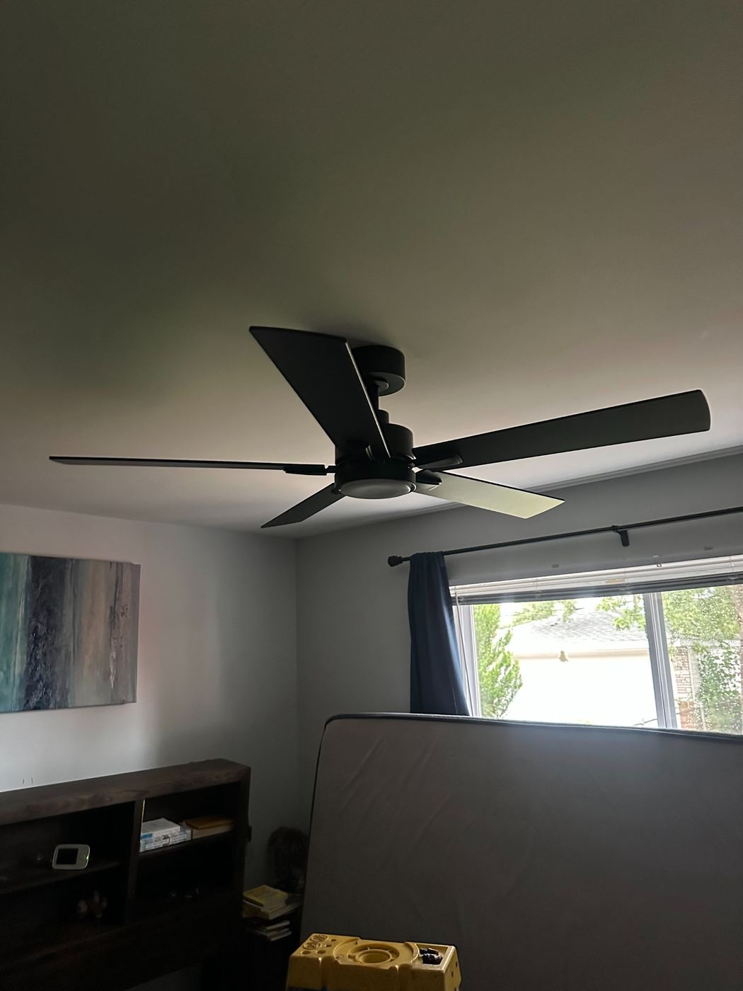 Matte black five blade ceiling fan with LED light installed by SLY Residential in a Metro Detroit bedroom