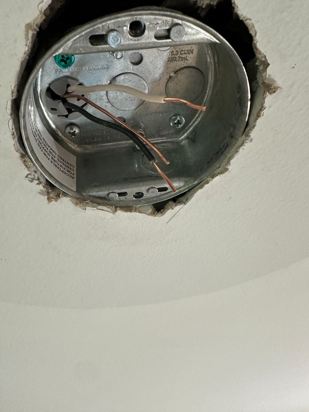 Open ceiling electrical box with exposed wiring before fan installation