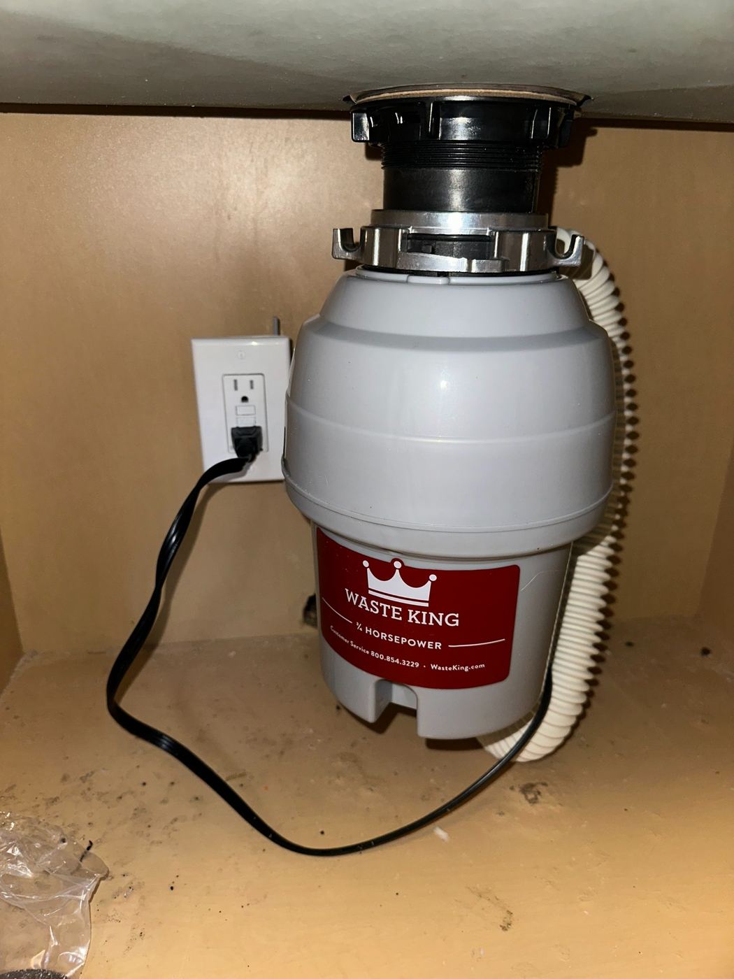 New Waste King garbage disposal installed under a kitchen sink by SLY Residential