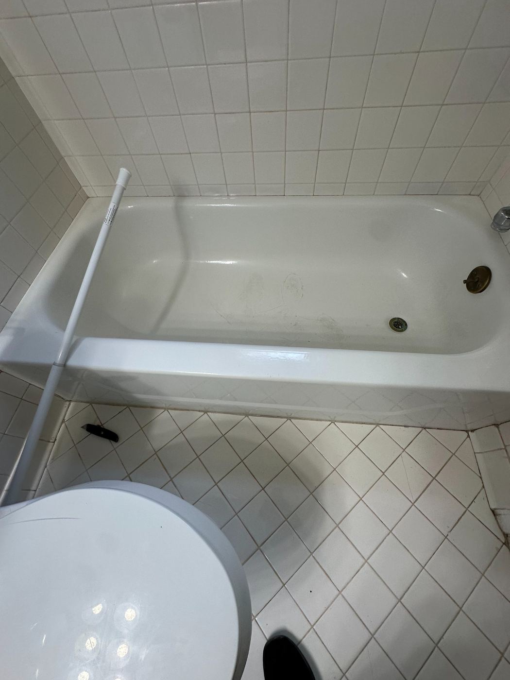 Bathtub with fresh caulk and refreshed fixtures completed by SLY Residential